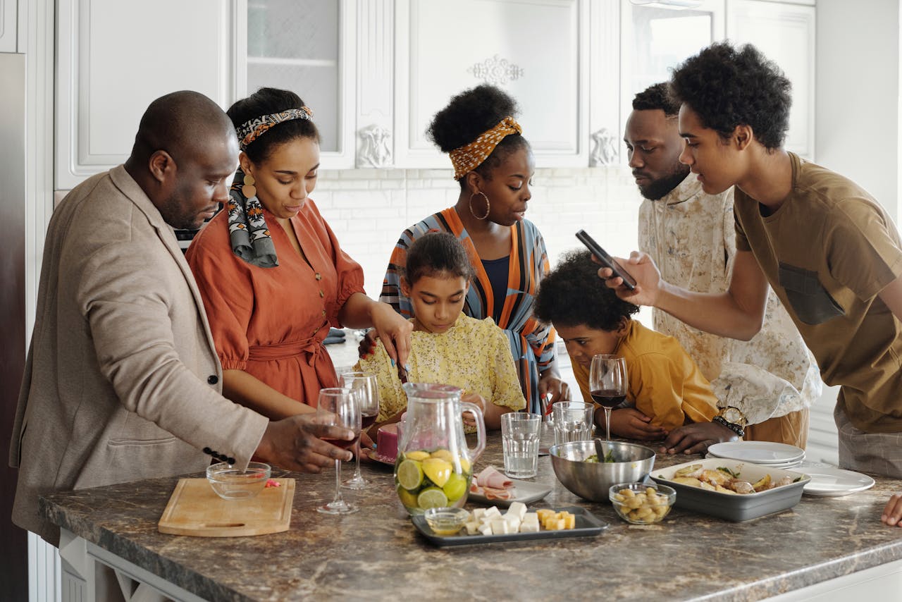 A joyful family gathering in the kitchen, enjoying food and drinks together.